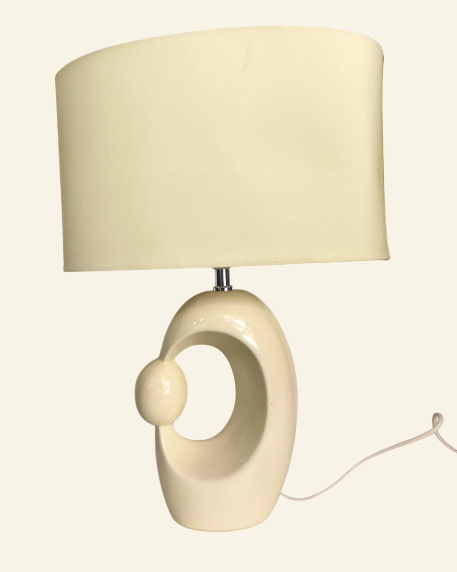 Cream ceramic table lamp with a mid-century design, featuring a lampshade.