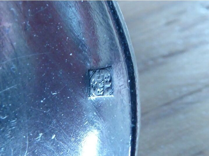 2 small white metal spoons