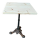 Bistro table with a raw wood top and a central cast iron base.