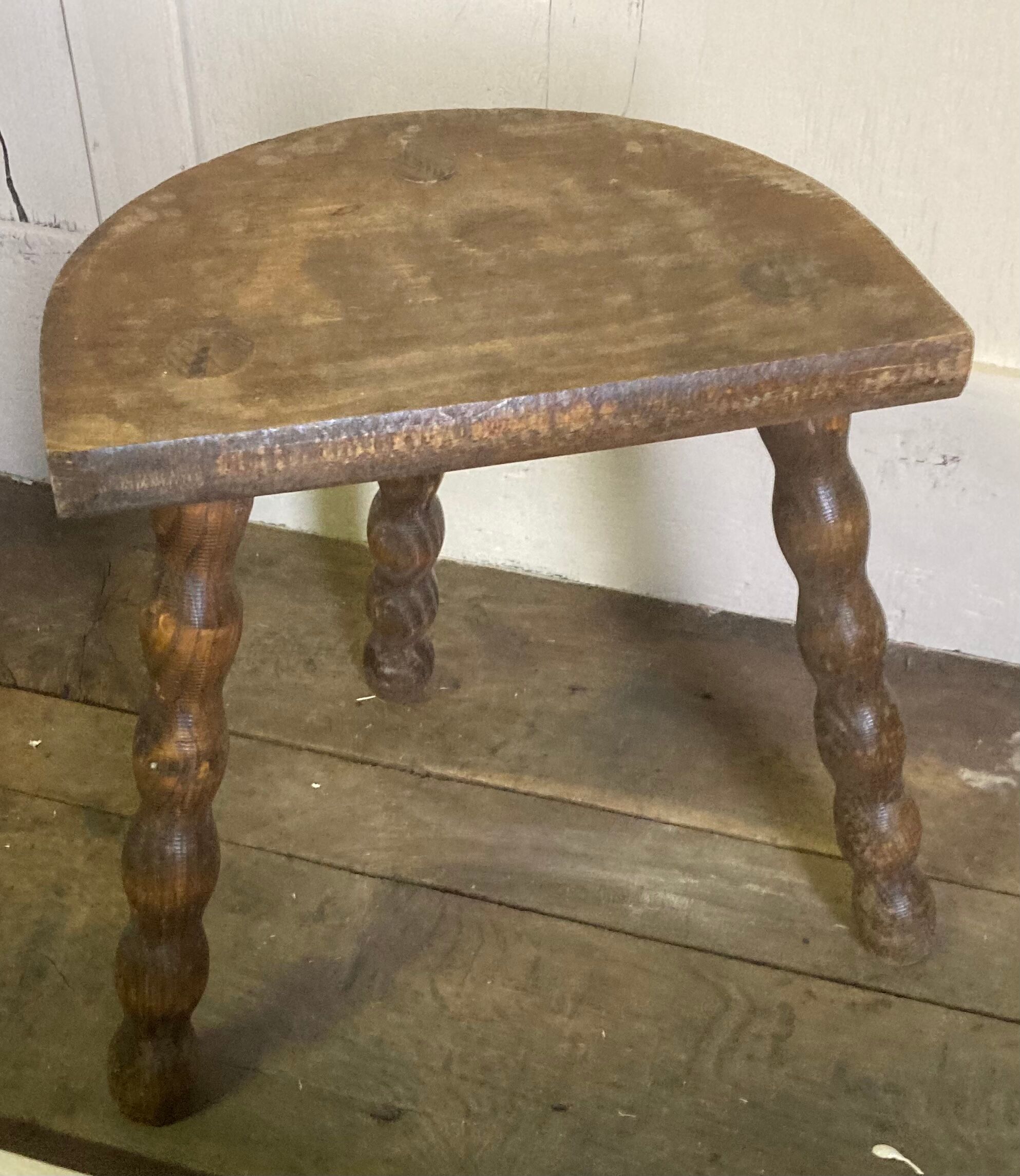 Half-moon tripod stool.