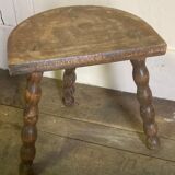 Half-moon tripod stool.