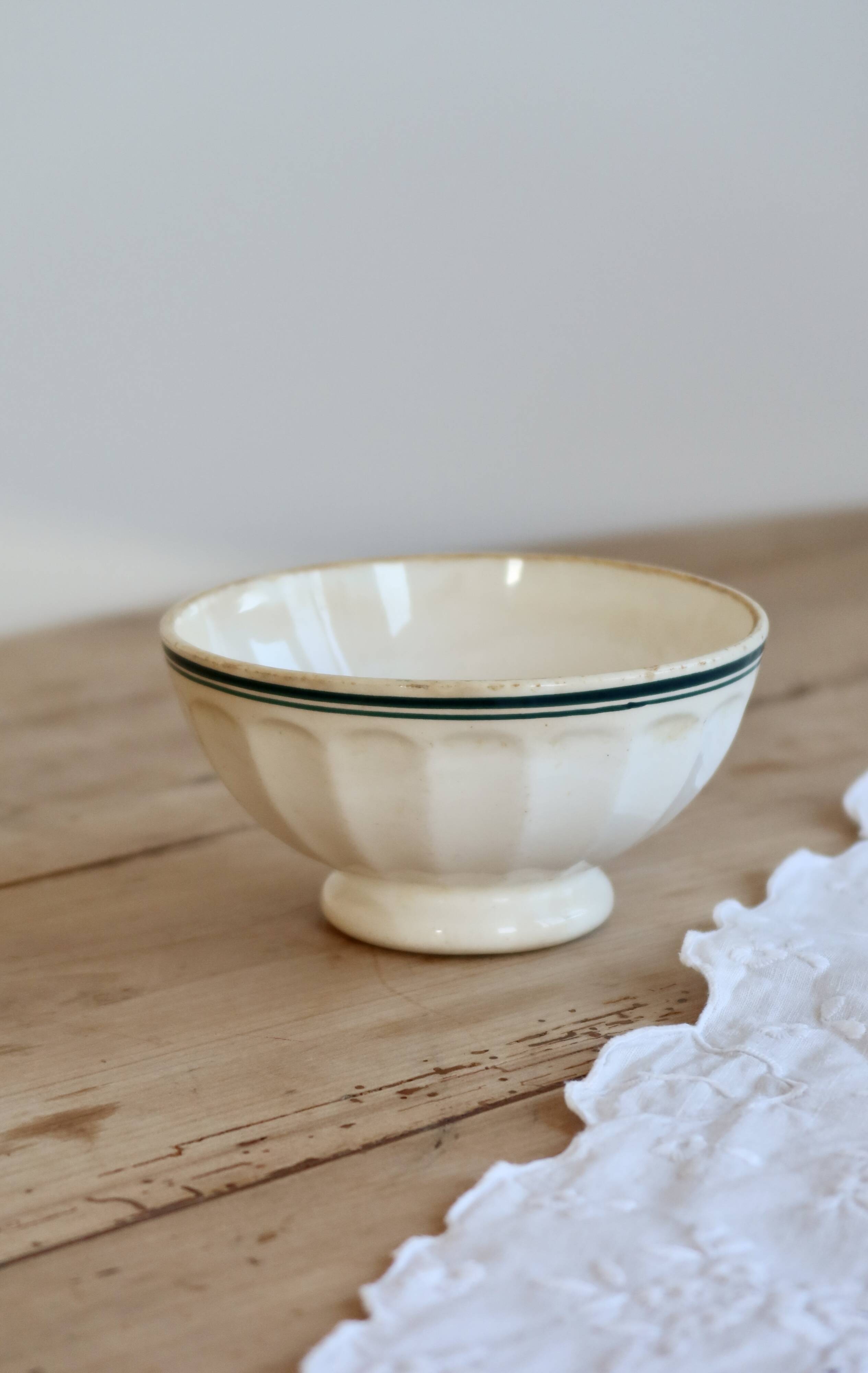 Old ivory ceramic bowl with double green trim.
