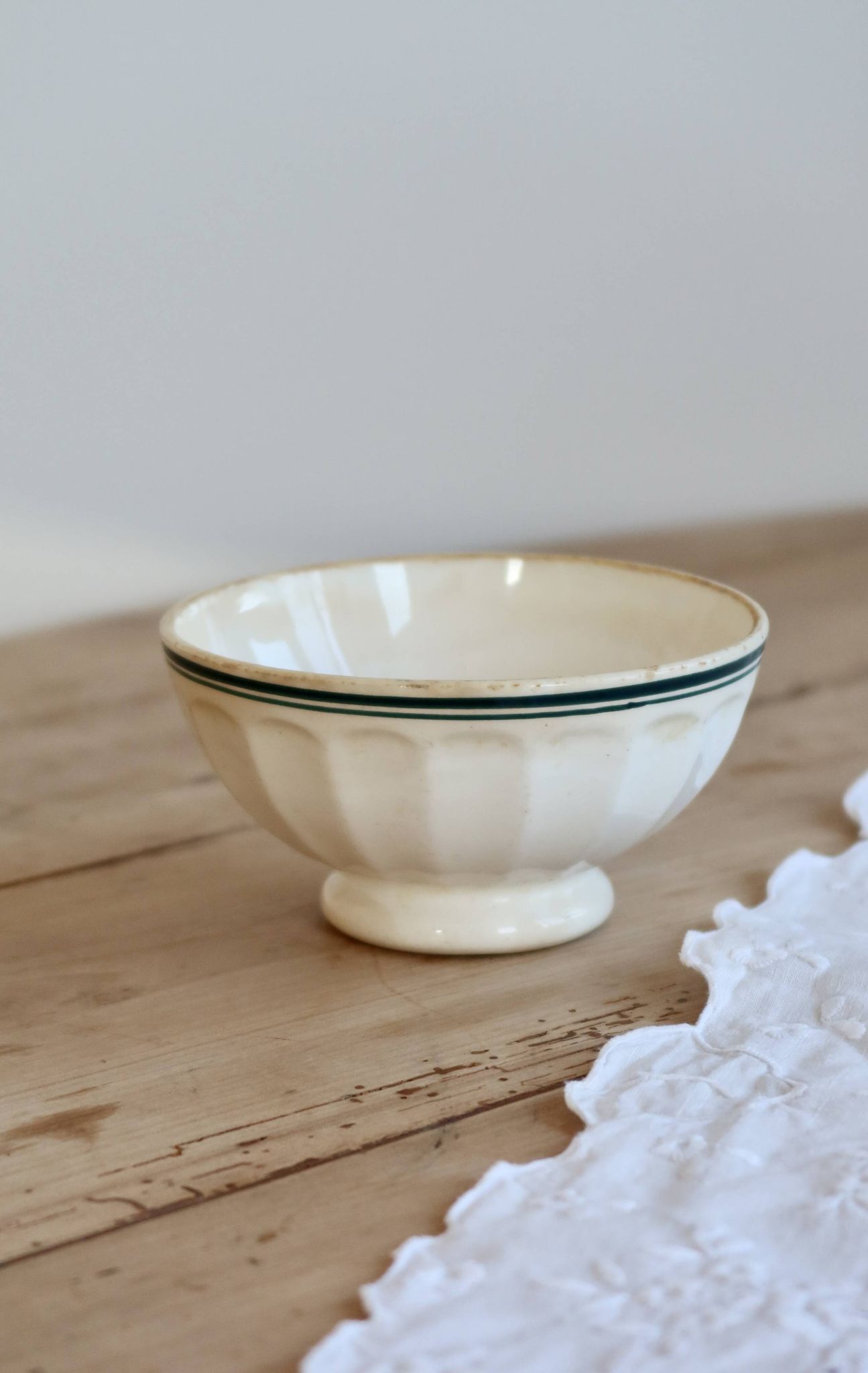 Old ivory ceramic bowl with double green trim.