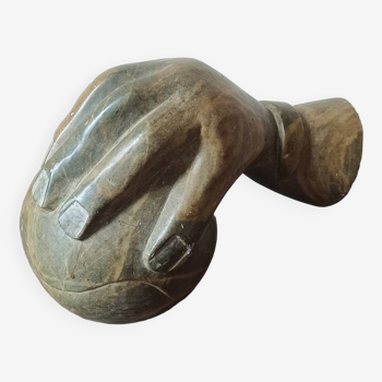 Sculpture main posée sur une boule en pierre, signée