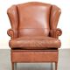 Fauteuil anglais à oreilles de couleur cognac clair en cuir de vache.