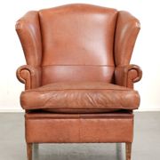 Light cognac-coloured English wingback armchair made of cowhide leather