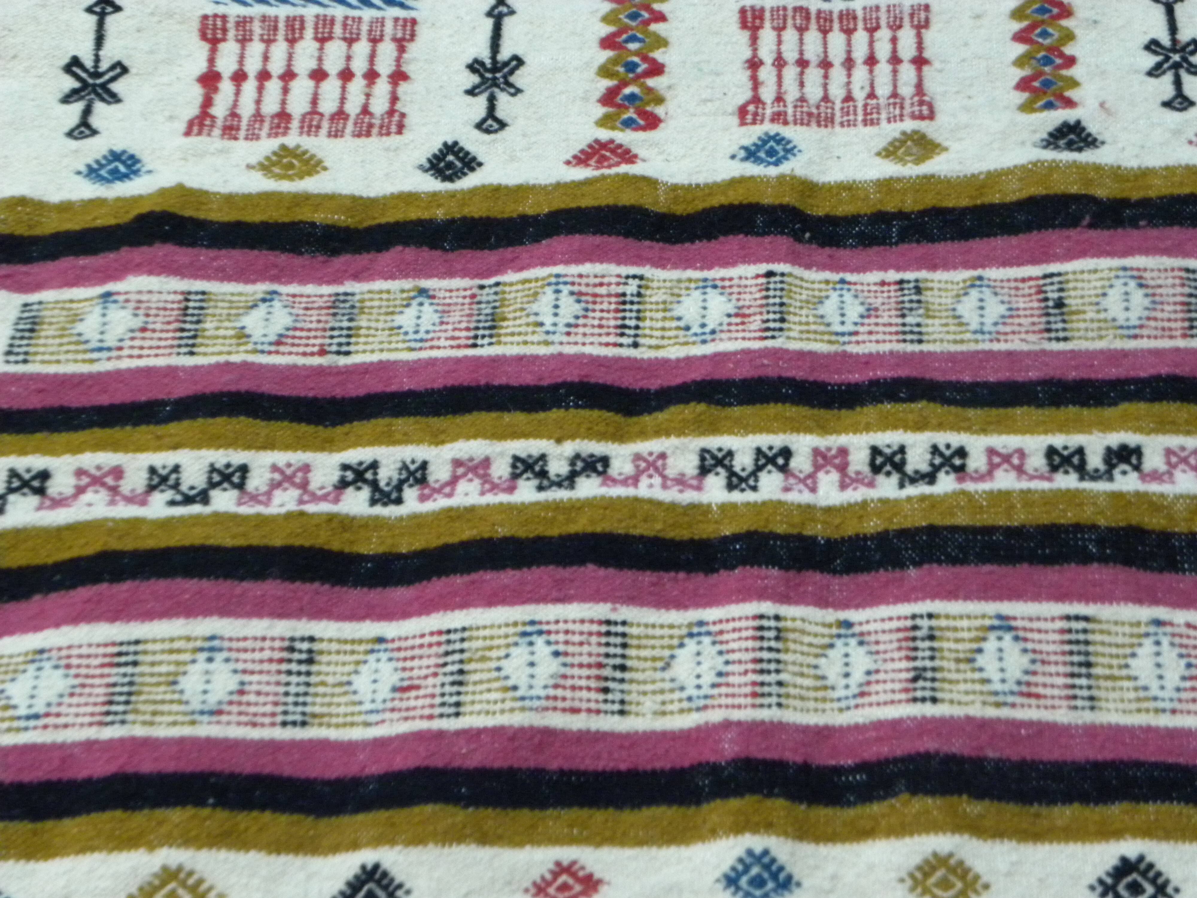 Handmade Berber kilim rug with multicoloured tribal motifs.