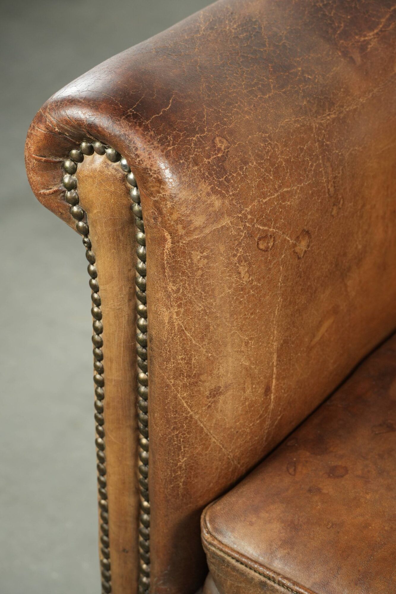 Vintage sheepskin club armchair finished with decorative nails