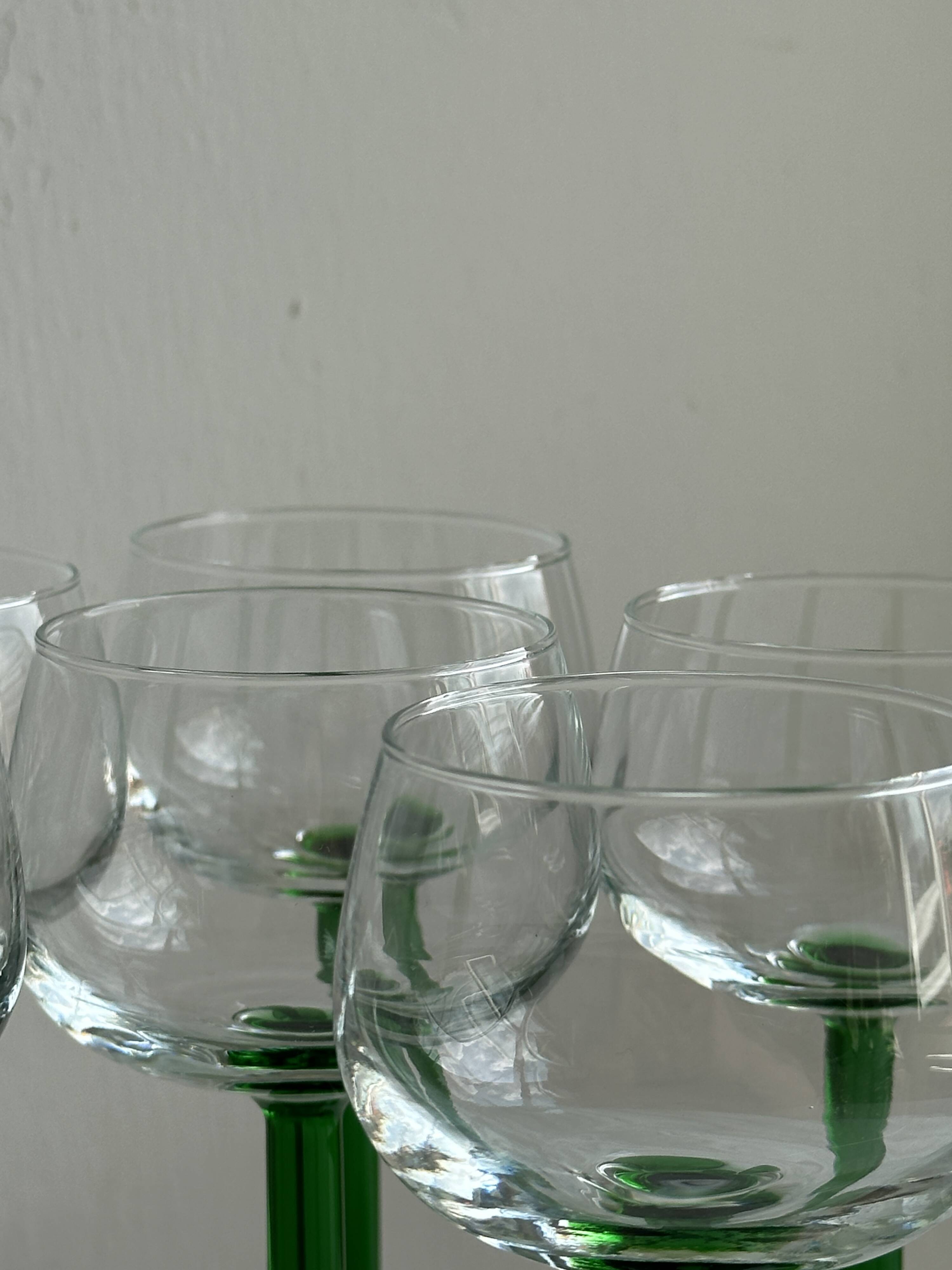 8 Alsatian stemmed glasses, transparent glass and green stems.