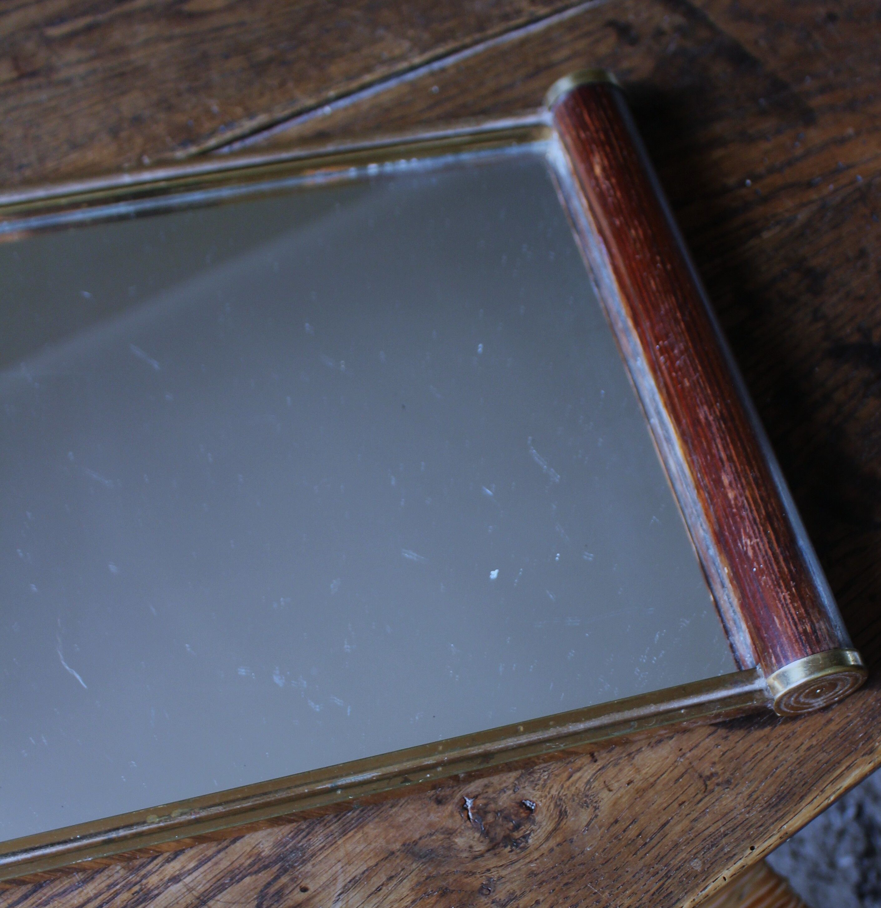 Rectangular mirror tray with wooden handles and gilding.