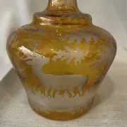 Amber bohemian glass liqueur carafe decorated with a stag in the forest.