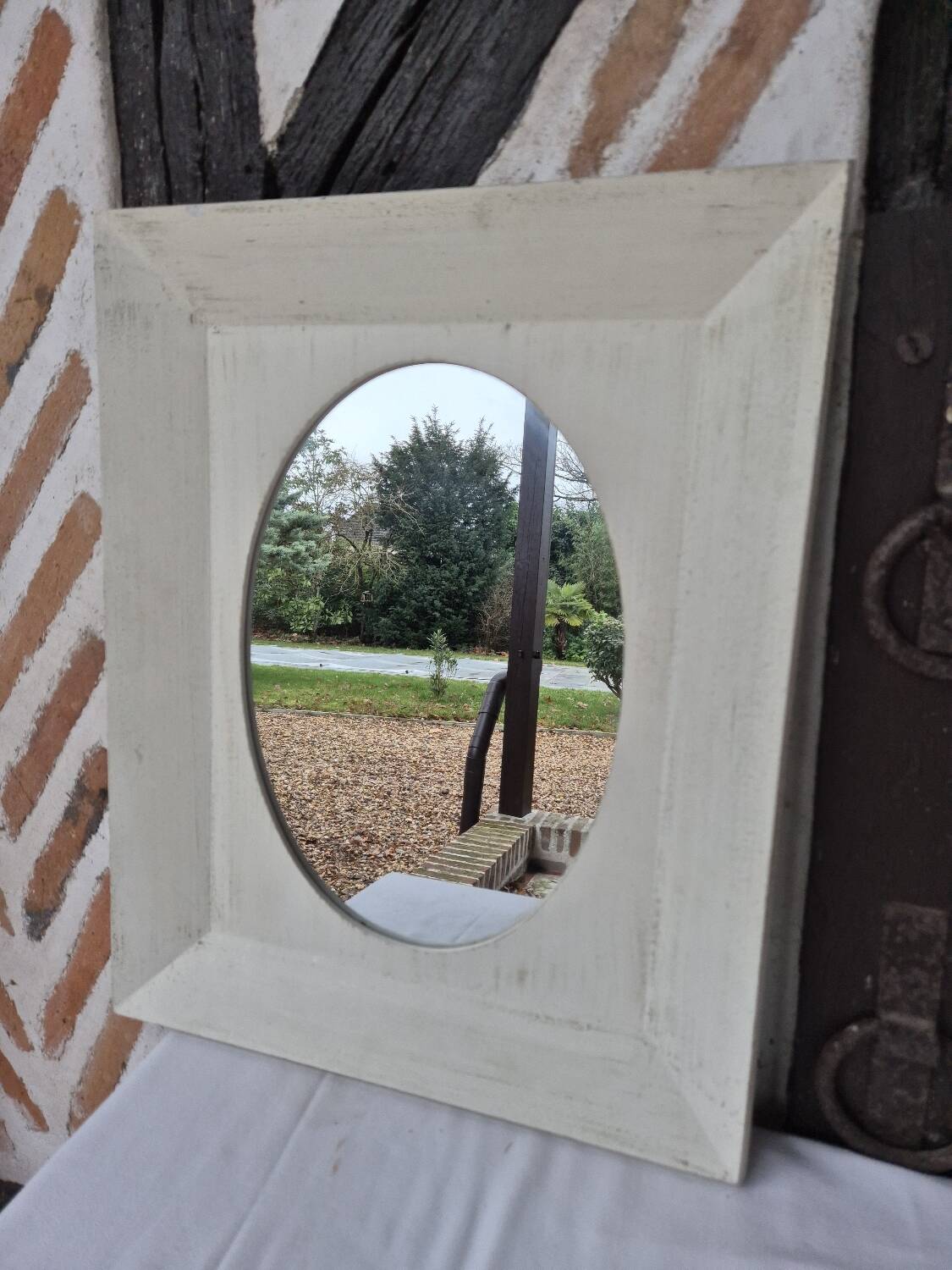 Oval mirror with a distressed white frame