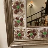Large square ceramic mirror with floral decoration.