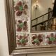 Large square ceramic mirror with floral decoration.