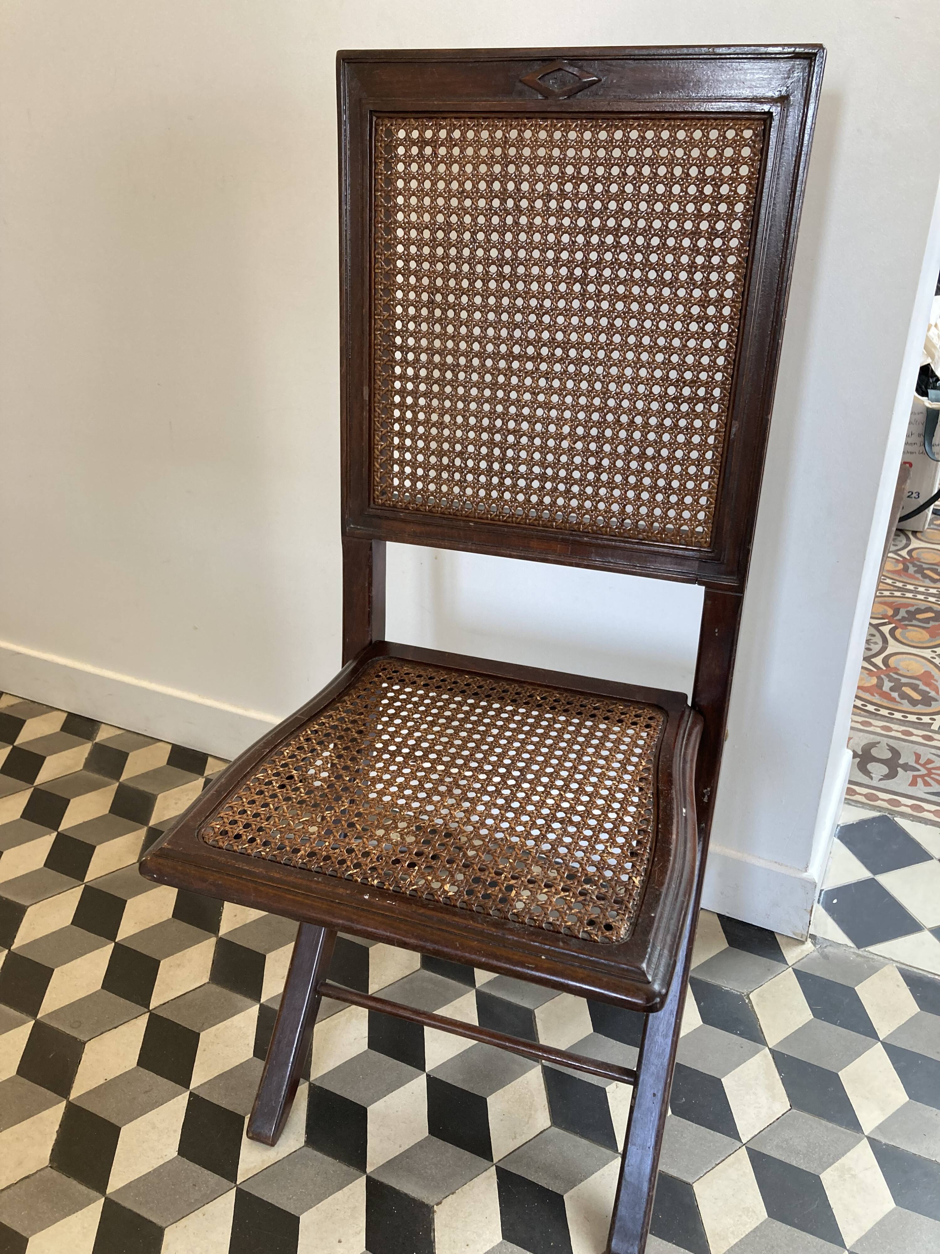 Vintage folding chair with cane seat in dark mahogany wood