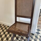 Vintage folding chair with cane seat in dark mahogany wood