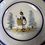 Large earthenware centerpiece dish with painted decoration of a drummer