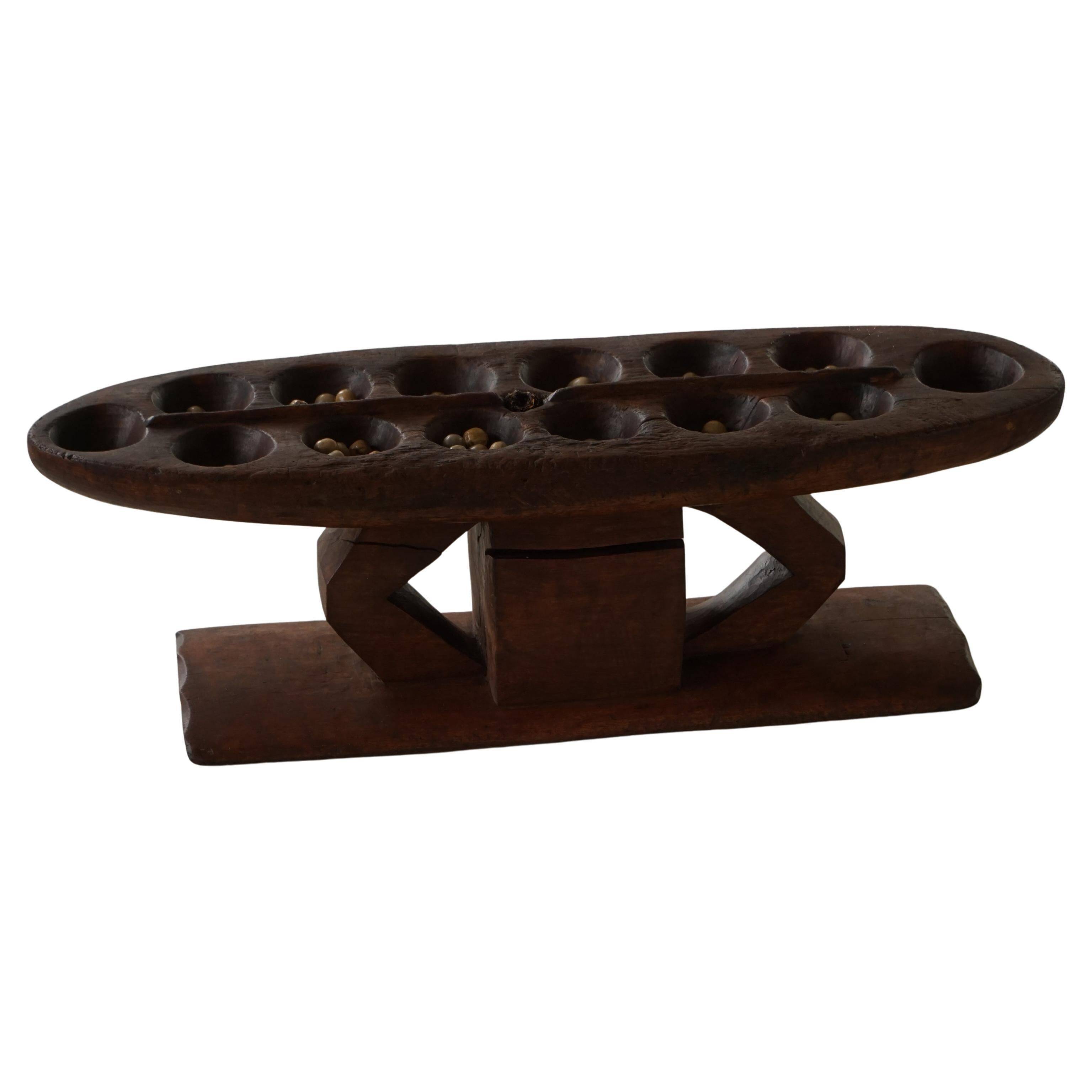 Decorative Mancala game board made of hand-carved wood, Africa, mid-20th century.
