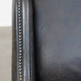 Black cow leather armchair in industrial style finished with decorative nails