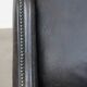 Black cow leather armchair in industrial style finished with decorative nails
