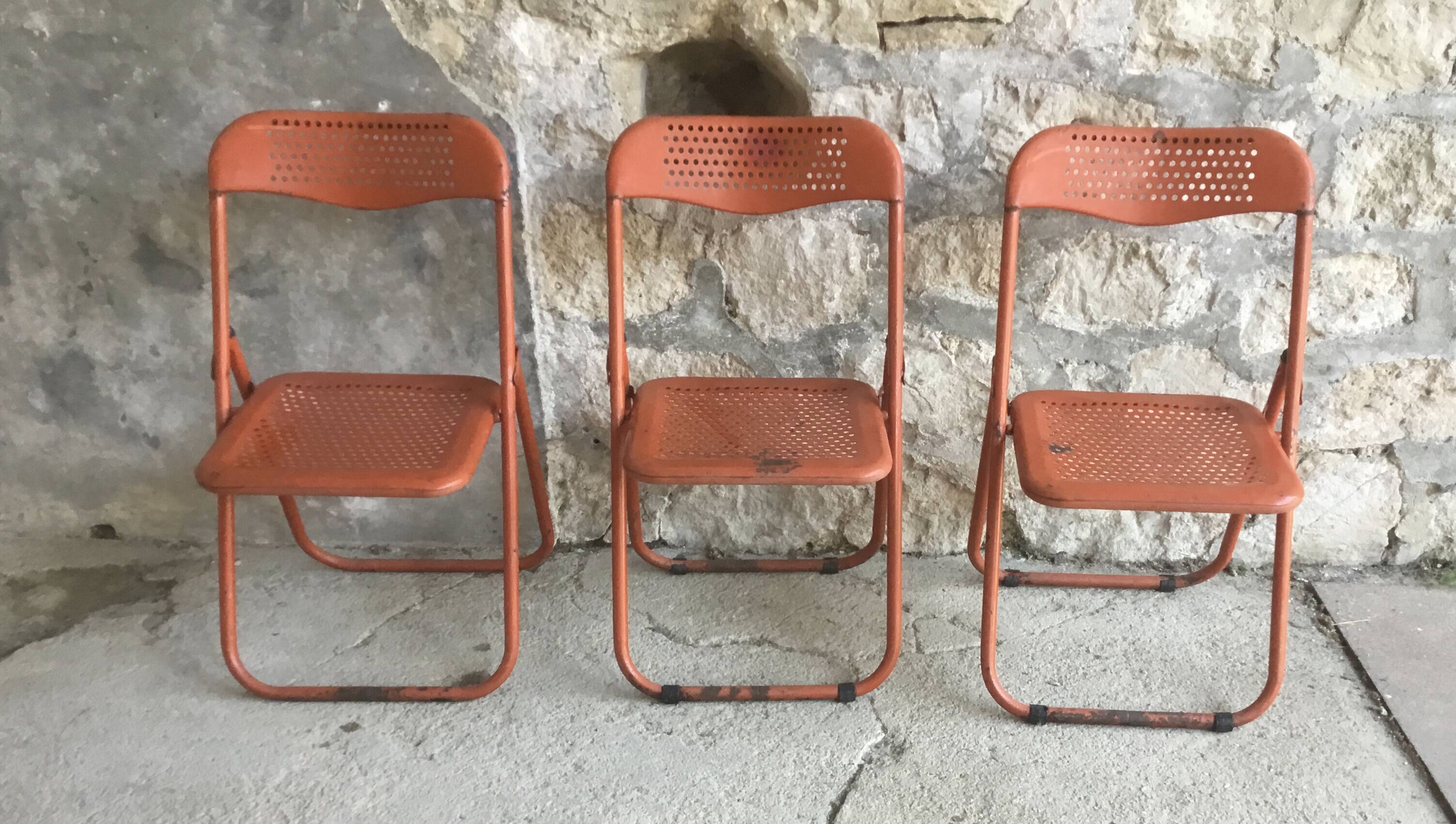 Trio of orange metal folding chairs - vintage