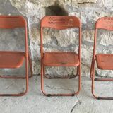 Trio of orange metal folding chairs - vintage