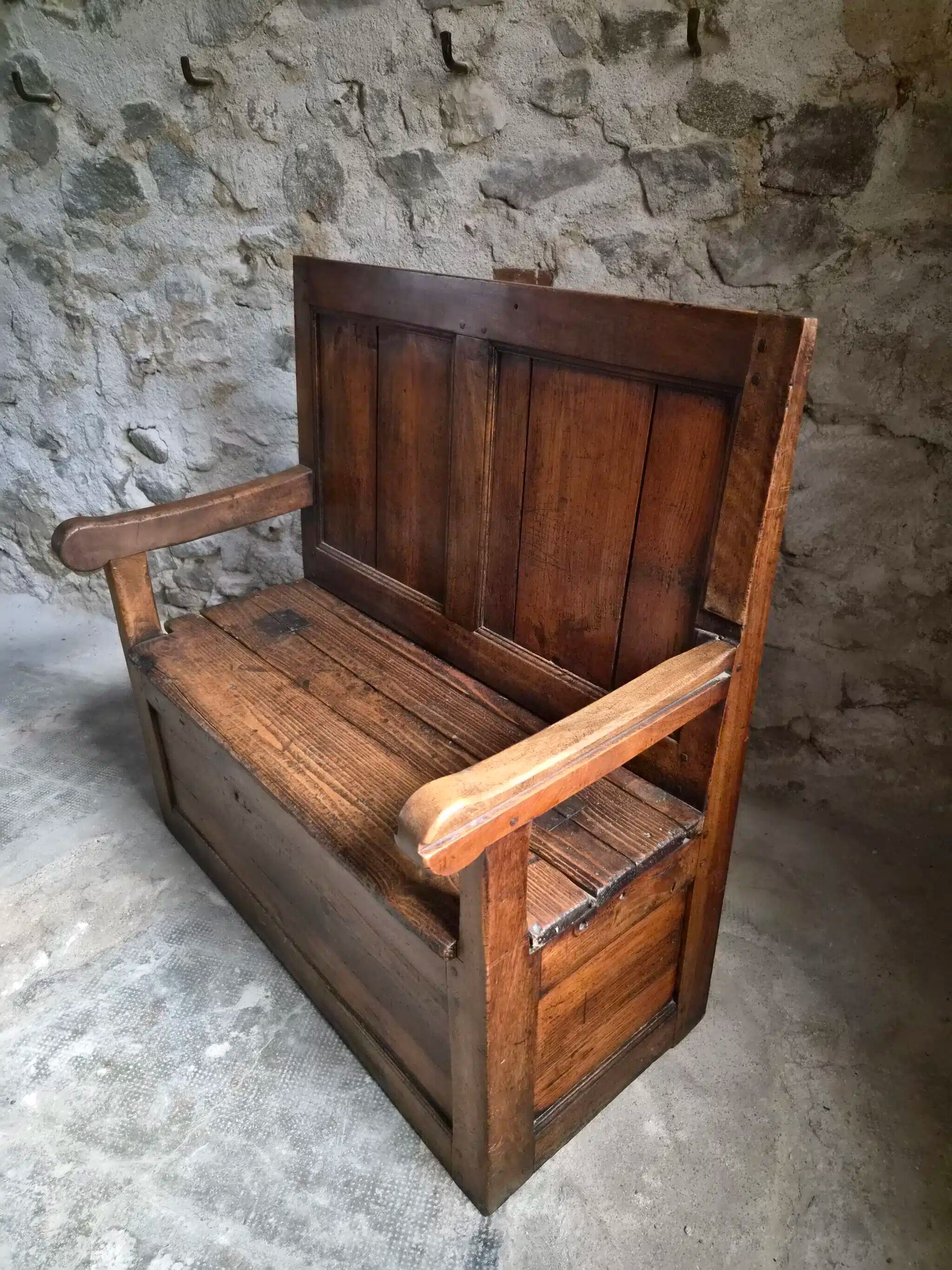 Rustic French antique storage bench from the 18th century in walnut and pine.