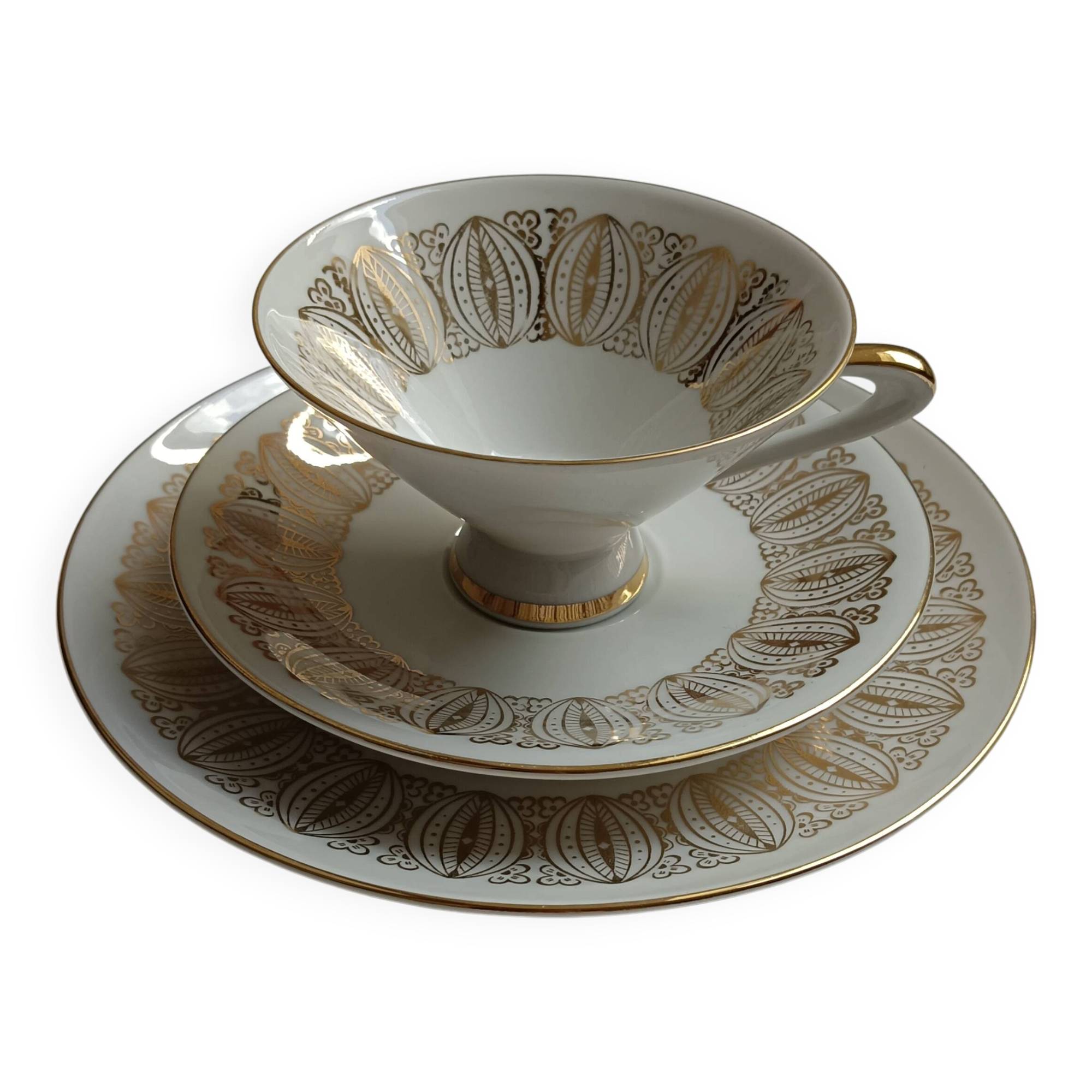 Solitaire tea cup, saucer, and dessert plate in white and gold.