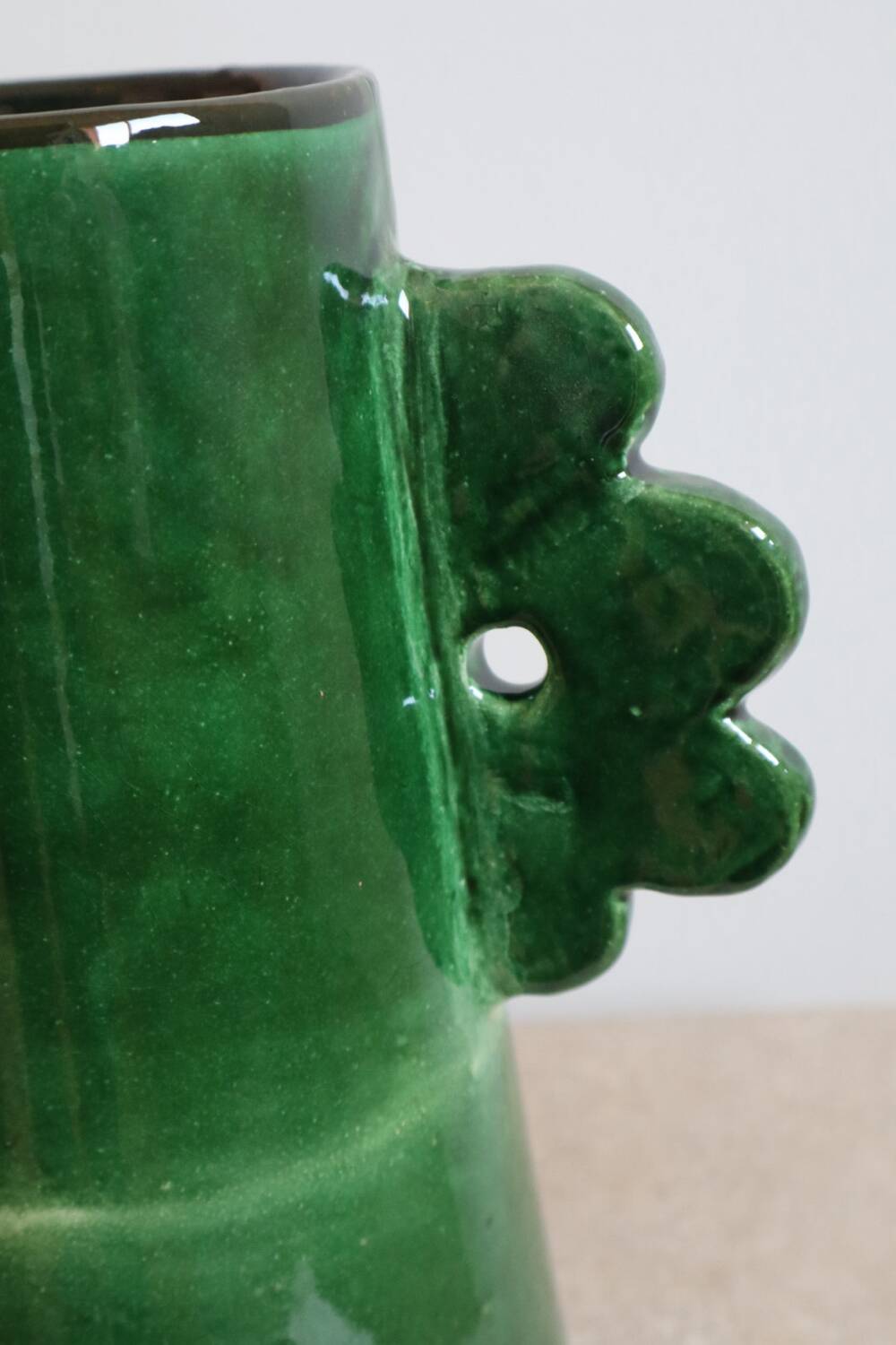 Handmade ceramic abstract vase with asymmetrical handles and fir green flowers