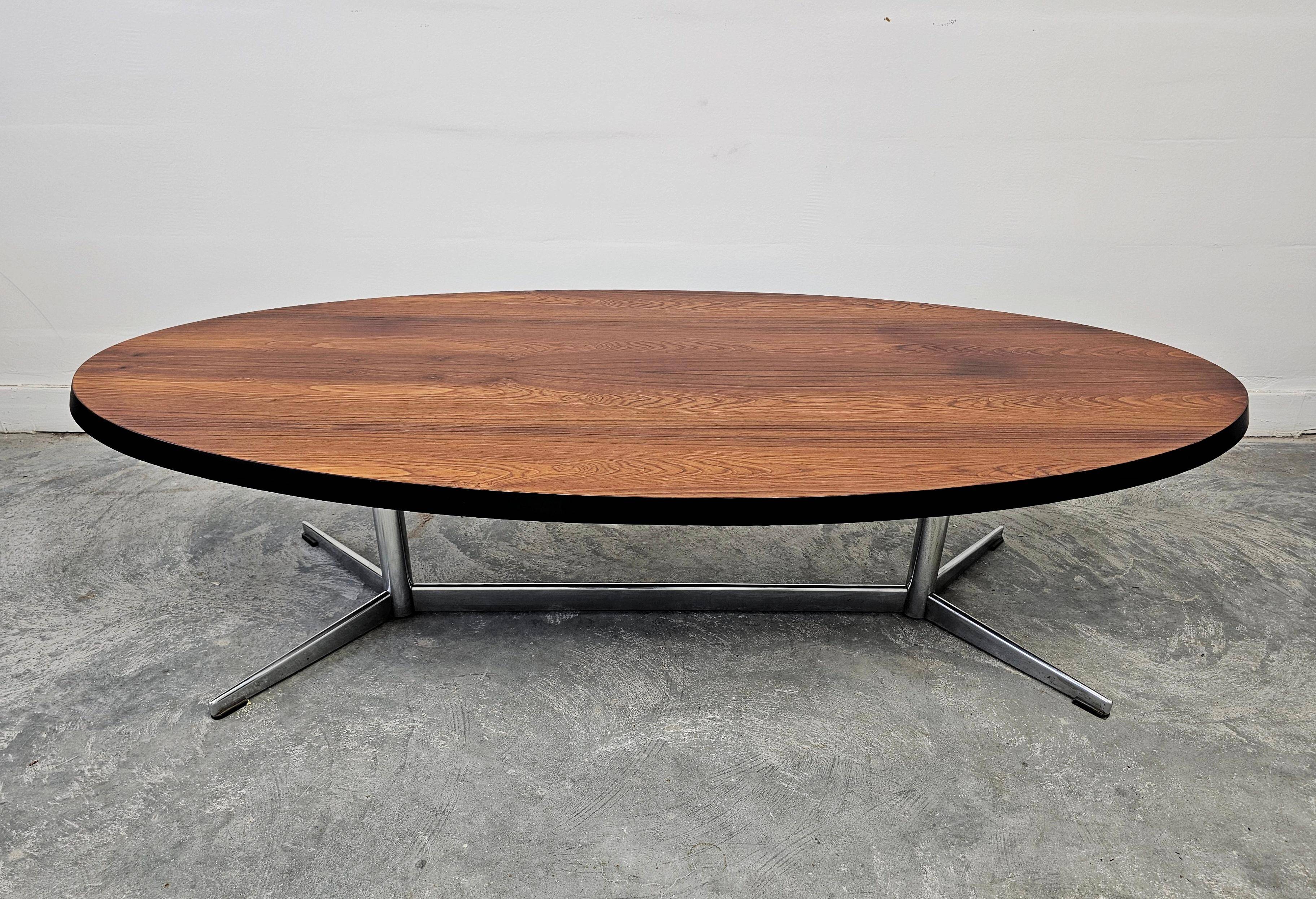 Danish Mid Century Modern oval coffee table with a teak top and chrome legs.