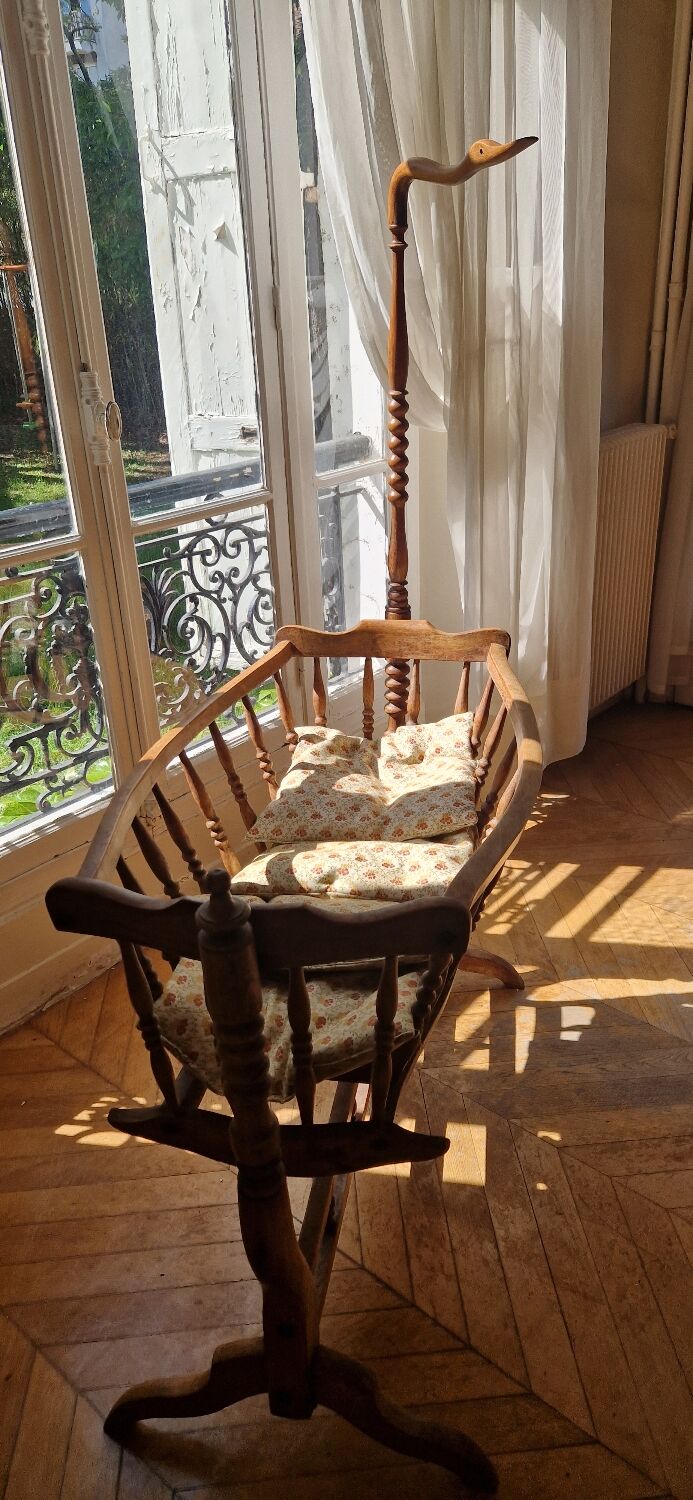 Wooden cradle in walnut with a sign collar at the top.
