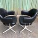 Pair of vintage armchairs in black skai with metal legs.