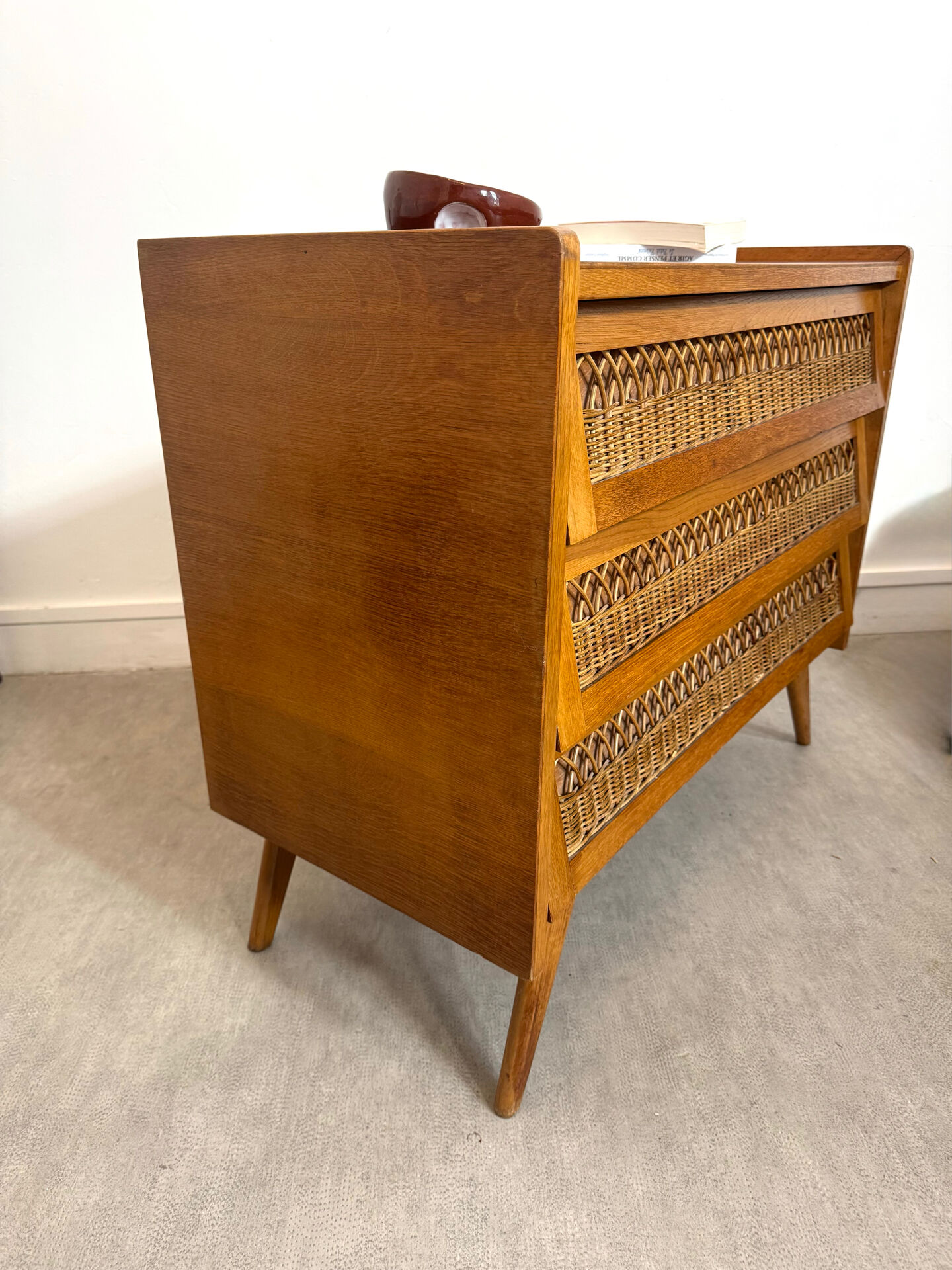 Vintage commode with tapered legs in rattan.
