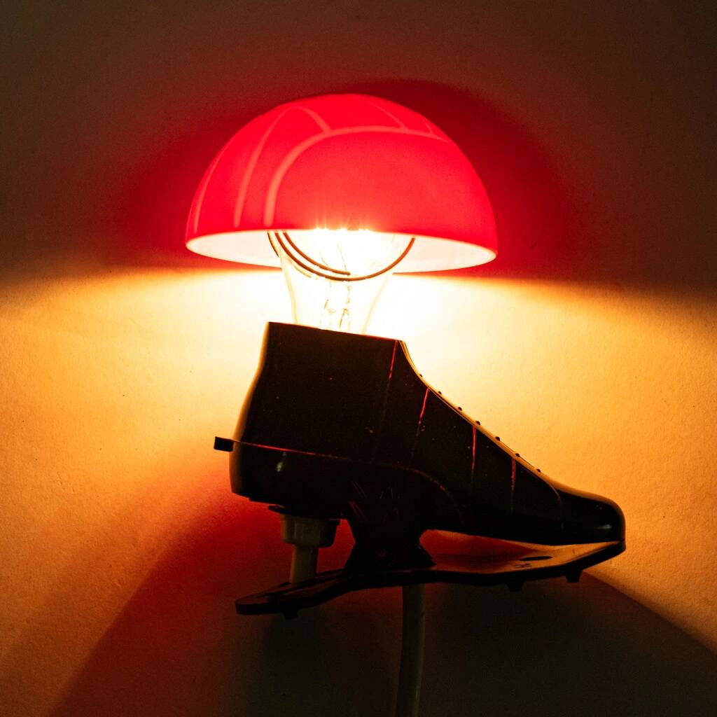 A small, wooden table lamp that stands on a tripod
