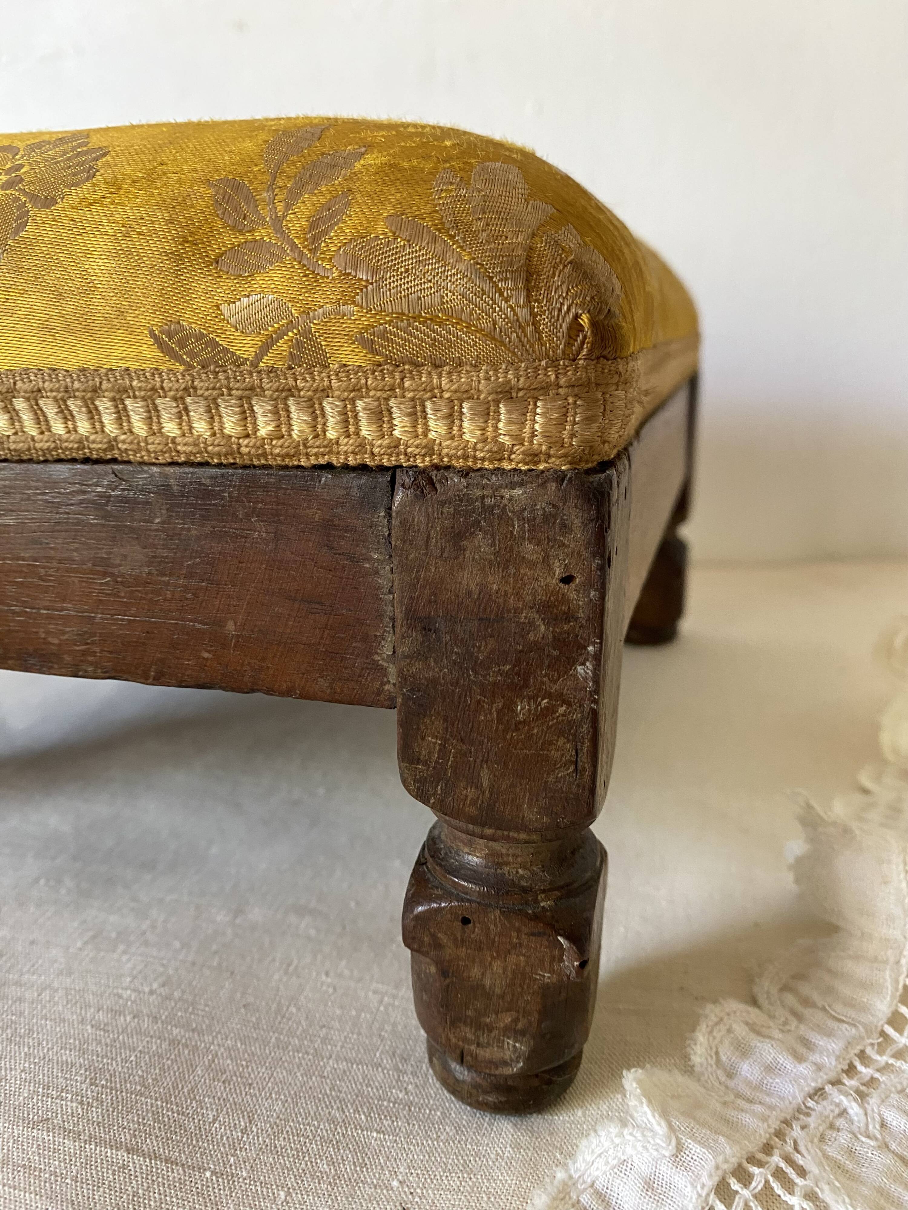 Low stool with antique wood and fabric footrest