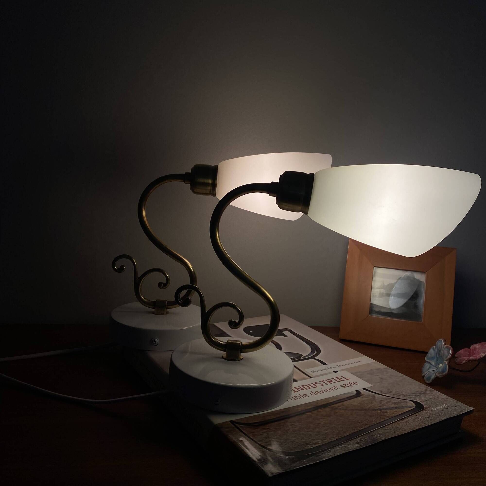 Pair of brass swan neck wall lights with white glass shades.