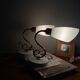 Pair of brass swan neck wall lights with white glass shades.