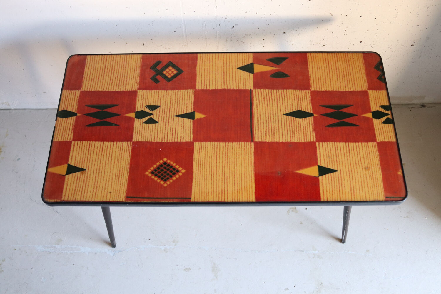 Vintage coffee table in laminate with geometric design, with tapered legs.