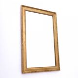 Horizontal mirror in a gold frame.