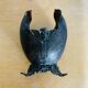 Antique decorative cup in hammered metal with putto design.