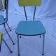 Two chairs and a yellow and blue stool in formica