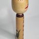 Japanese Kokeshi doll dated 1986, signed and numbered, hand-painted multi-colored floral decoration,