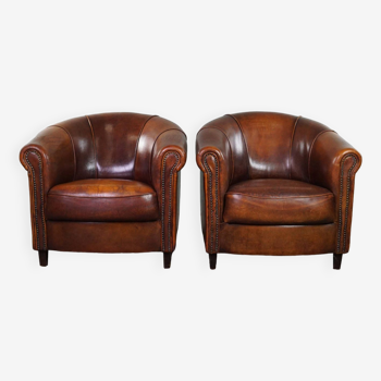 Ensemble de deux fauteuils club en cuir de mouton d'une belle couleur sombre et chaleureuse