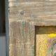 Rectangular Indonesian construction element with blue and yellow plant in carved wood