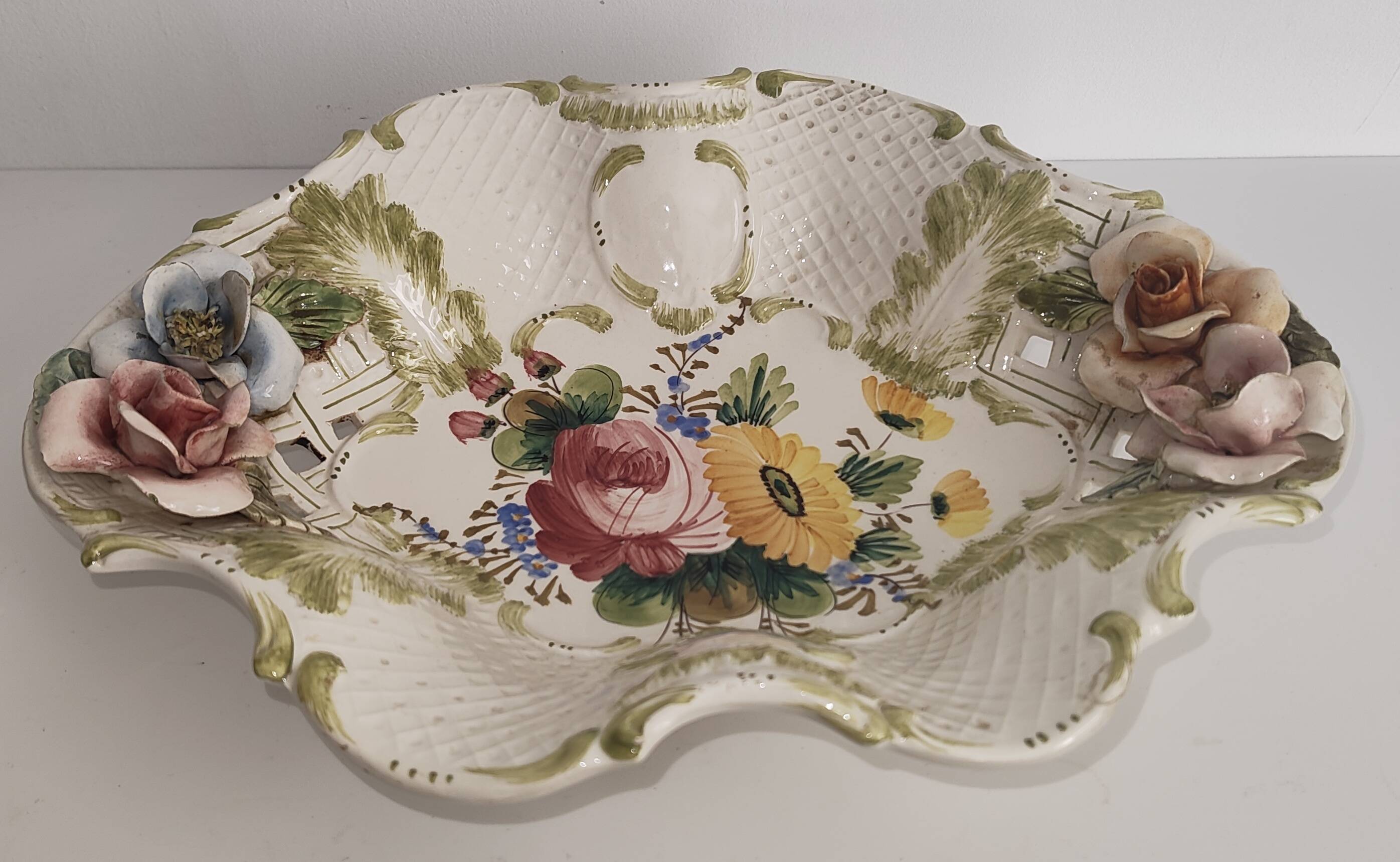 Openwork ceramic bowl with raised flower decoration in Italian style.
