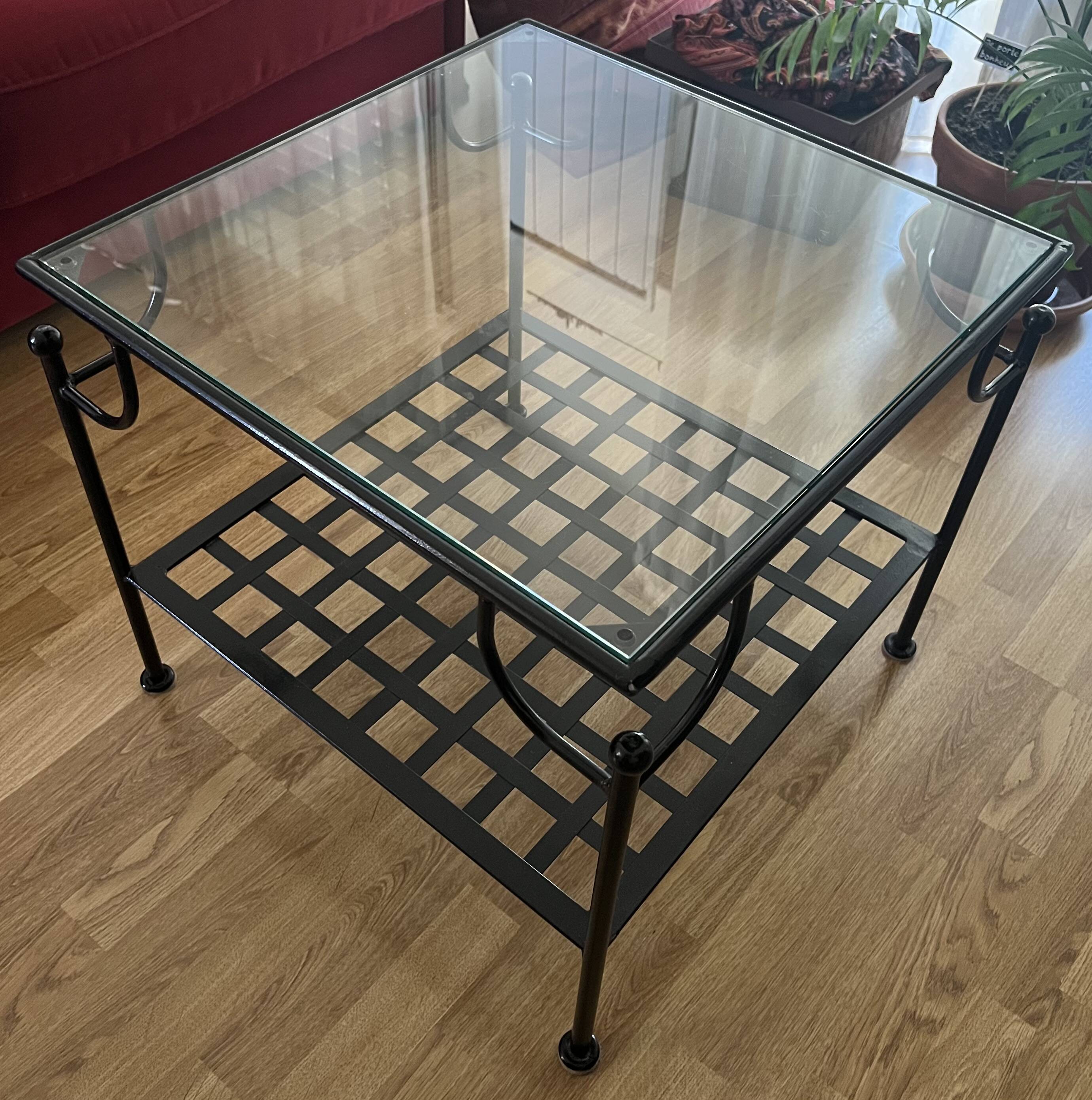 Coffee table with a glass top and black metal frame.