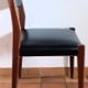 Four antique Scandinavian-style chairs made of solid wood and faux leather.