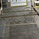 Patinated metal and wood double bed with integrated bedside tables.