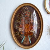 Frame of dried flowers under domed glass