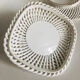 Covered basket in white woven ceramic and fruit slip.